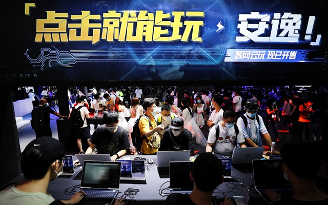 参观者在游戏体验区现场试玩电脑游戏。